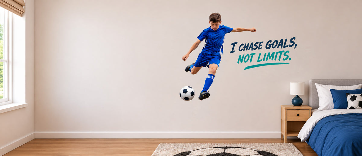 Custom wall sticker of a boy kicking a football in a bedroom, with the words “I chase goals, not limits”